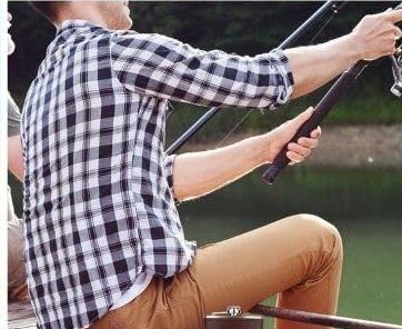 The flask on a dock next to a man fishing