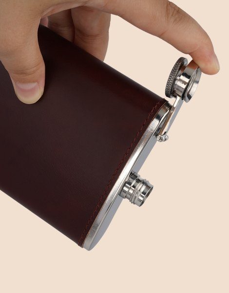 A hand holding the flask with the swing-arm cap open