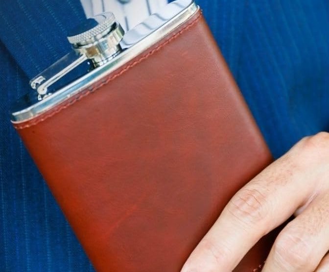 The flask held against a blue suit jacket